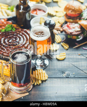 Oktoberfest, birra e snack impostato su scorched scuro dello sfondo in legno Foto Stock