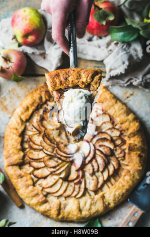 Mano d'uomo azienda fetta di apple in casa la crostata Foto Stock