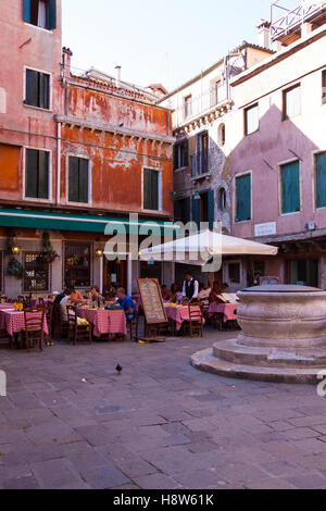 Un Cafe' in una vecchia piazza di Venezia che mostra il cliente seduto a tavoli esterni Foto Stock