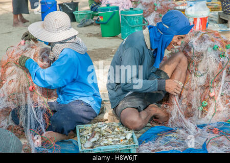 Popolo Thai raccogliere delle catture di frutti di mare dalla rete da pesca in un villaggio a sud di Hua Hin Foto Stock