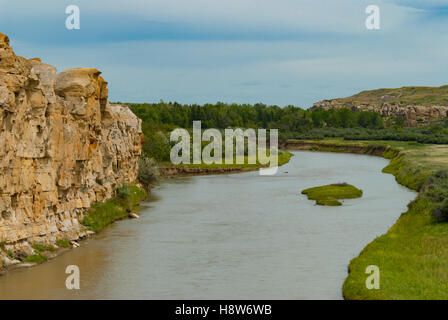 Il fiume di latte che fluisce oltre scogliere di arenaria per iscritto-su-pietra Parco Provinciale, nel sud dell'Alberta. Foto Stock