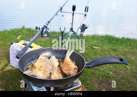 Preparazione del pesce fritto in padella all'aperto sulla pesca Foto Stock