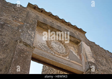 Il rilievo della corona di alloro sulla porta d'ingresso alla villa romana, Pompei, Italia. Foto Stock