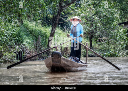Donna canottaggio un sampan barca sul fiume Mekong in Cai Be, il Delta del Mekong, Vietnam Asia Foto Stock