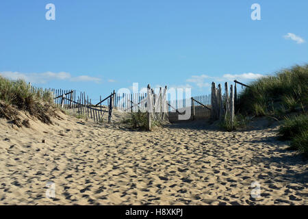 Malsicuro staccionata in legno, in mezzo alle dune di sabbia, segnando il modo di entrata per la gara Point Beach, Cape Cod, Massachusetts Foto Stock