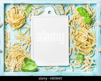 Vari fatti in casa non cotte fresche pasta italiana e bianco scheda di ceramica Foto Stock