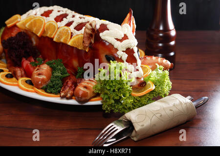 Il maialino arrosto con decor di verdure su grande lastra Foto Stock