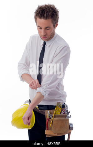 Giovane imprenditore con un utensile a cinghia e un elmetto, arrotolando il suo manicotto Foto Stock