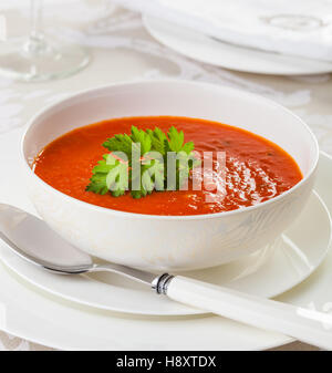 Freschi Fatti in casa zuppa di pomodoro in una ciotola bianco, guarnite con prezzemolo. Foto Stock