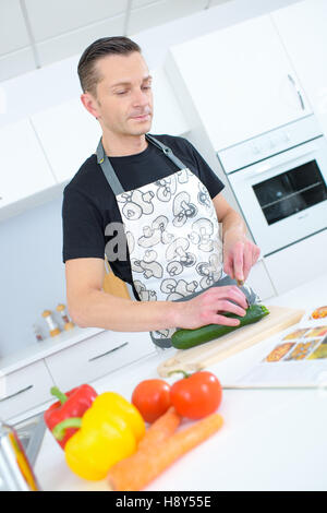 Medio-età uomo cottura a casa Foto Stock