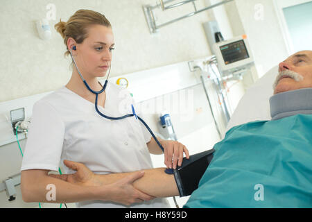 Medico donna la misurazione pressione sanguigna del paziente Foto Stock