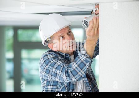 Workman sostituzione grondaie sull esterno della casa Foto Stock