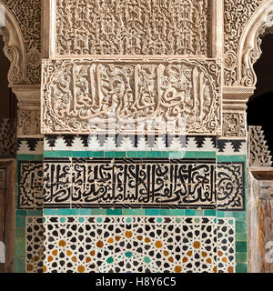 Calligraphy e decorazione zellij sulla parete in Madersa Bou Inania. Con le tipiche pianelle in terracotta smaltata zellij marocchine, i mosaici in scala ridotta vengono posati con la tecnica Girik Foto Stock