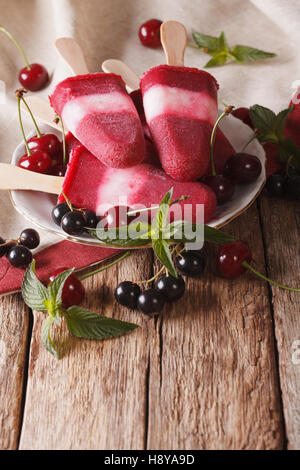 Gustosi piatti fatti in casa berry sorbetto alla menta su un bastone close up sul piano verticale. Foto Stock