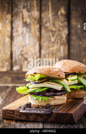 Verdure grigliate e haloumi burger con lattuga romana sul tavolo di legno Foto Stock