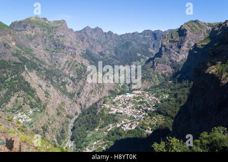 Vista da sopra di una piccola cittadina Curral das Freira in montagna, villaggio circondato da montagne rocciose Foto Stock