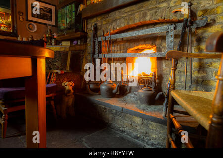 Camino in stile rustico con un fuoco illuminato in un pub di campagna in Irlanda. Foto Stock