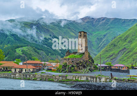 Le rovine del castello medievale di sno villaggio con alta torre in pietra, costruito presso la banca di fiume Snostskali, Georgia. Foto Stock