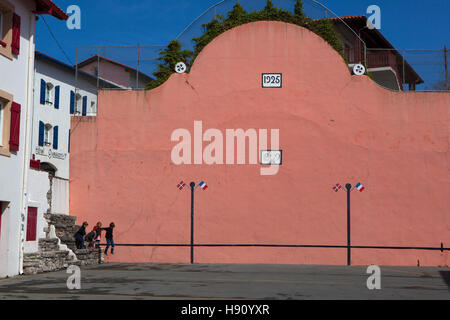 I bambini che salta da un muro nella pelota tribunale della città di Bidart, Biarrtiz, Paese Basco, Francia Foto Stock