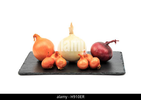 Cipolle, marrone, bianco e viola con scalogno e sul nero ardesia bordo isolati su sfondo bianco Foto Stock