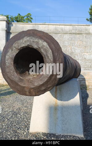 Vecchio arrugginito Artiglieria Navale cannone in pietra bianca Closeup piedistallo Foto Stock