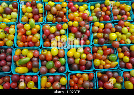 Colorati misti cimelio di pomodori ciliegia disposti nel mercato verde cesti Visualizza configurazione di cui sopra Foto Stock