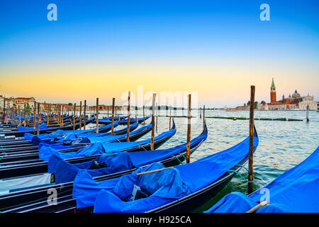 Venezia, gondole o gondole su un blu crepuscolo al tramonto e la chiesa di San Giorgio Maggiore punto di riferimento sullo sfondo. L'Italia, l'Europa. Foto Stock