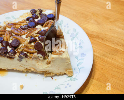 Cheesecake con dadi e scaglie di cioccolato con una forcella di andare in Foto Stock