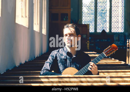 Giovane maschio musicista classico con una chitarra Foto Stock