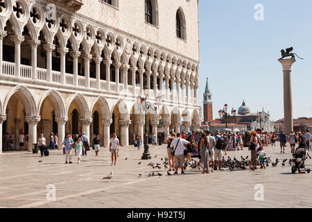 Turisti che nutrono i piccioni fuori dal Palazzo Ducale, Piazza San Marco, Venezia, Italia. Foto Stock