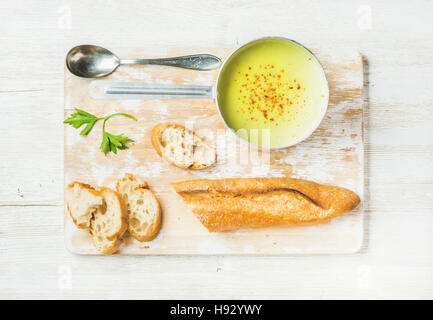 Verde zuppa vegetale nel convogliatore con prezzemolo e baguette Foto Stock
