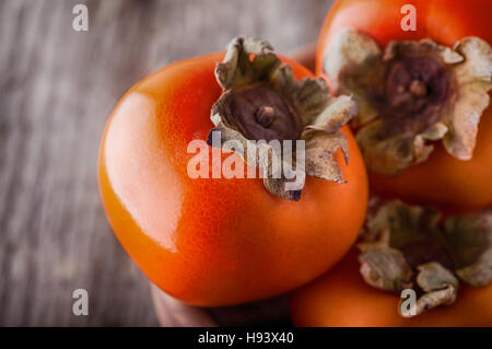 Arance fresche Cachi su un tavolo di legno. Foto Stock