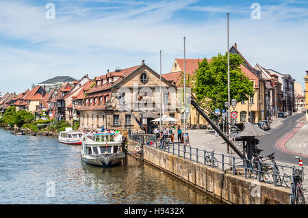 Tourist Imbarcazioni da fiume e un retro derricks al fiume Regnitz a Bamberg. Foto Stock