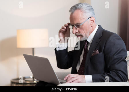 Imprenditore concentrato di lavorare con il notebook all'hotel Foto Stock