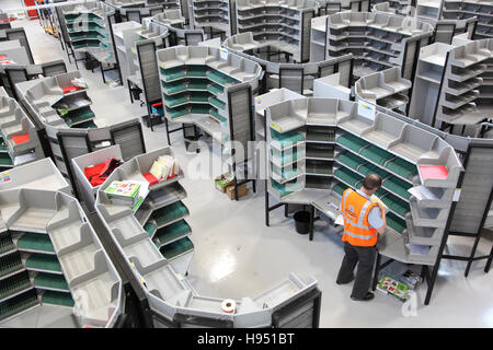 Un singolo postino lavora ad una scrivania di ordinamento in un nuovo ufficio postale ufficio di smistamento nel sud dell'Inghilterra, Regno Unito Foto Stock
