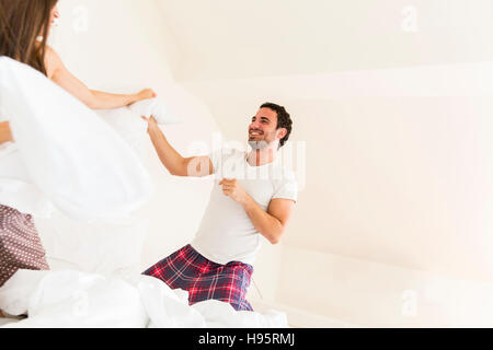 Paio di divertirsi con un cuscino lotta nel letto Foto Stock