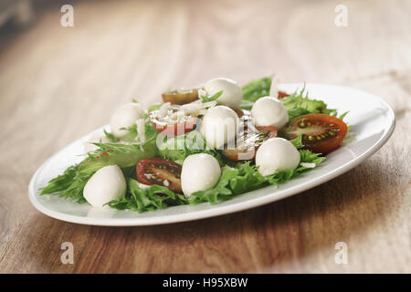 Insalata con kumato pomodoro, mozzarella, frillies lattuga e parmigiano grattugiato Foto Stock