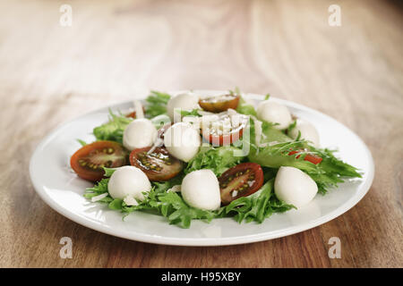 Insalata con kumato pomodoro, mozzarella, frillies lattuga e parmigiano grattugiato Foto Stock