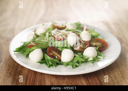 Insalata con kumato pomodoro, mozzarella, frillies lattuga e parmigiano grattugiato Foto Stock