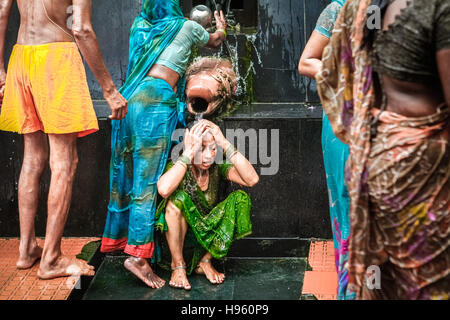 Una donna pilgim che prende un bagno in acqua Santa da una sorgente calda al complesso di tempio di Lakshmi Narayan in Rajgir, Bihar, India. Foto Stock