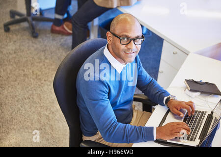 Ritratto imprenditore lavora al computer portatile in ufficio Foto Stock