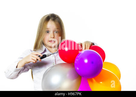 Funny bambina che soffia su baloons colorati, isolato su sfondo bianco Foto Stock