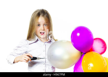 Funny bambina che soffia su baloons colorati, isolato su sfondo bianco Foto Stock