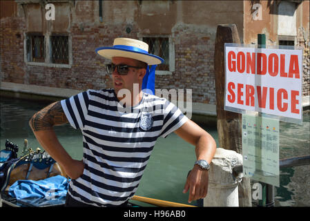 Gondoliere con il tipico copricapo su un canale di Venezia in Italia. Foto Stock