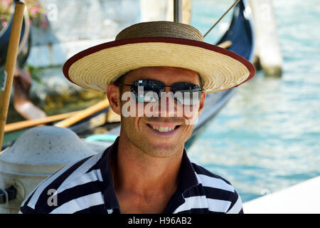 Gondoliere con il tipico copricapo su un canale di Venezia in Italia. Foto Stock