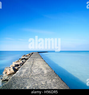 Calcestruzzo e rocce molo o pontile su un oceano blu acqua. Fotografie con lunghi tempi di esposizione Foto Stock