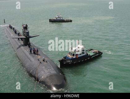 Un rimorchiatore guida l'USN Los Angeles-classe fast-attacco sommergibile USS Bremerton durante una visita di porta 21 giugno 2011 in Mina Salman, Bahrain. Foto Stock