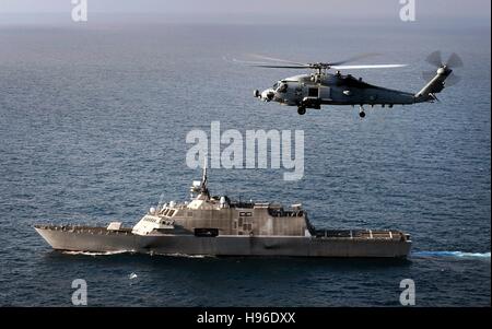 Un MH-60R Seahawk multi-missione elicottero vola a fianco della USN libertà-class Littoral Combat Ship USS libertà mentre in corso Giugno 7, 2011 nell'Oceano Pacifico. Foto Stock