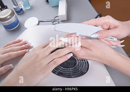 Manicure. Elaborazione dei chiodi estesa da una lima per unghie Foto Stock