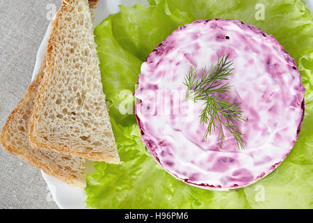 Insalata "aringa sotto una pelliccia"su una piastra bianca Foto Stock